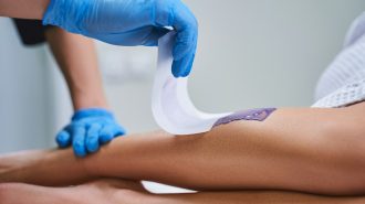 Cosmetologist doing waxing for woman stock photo