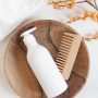 White plastic bottle with pump mock up, used for shampoo and conditioner for hair and wood comb